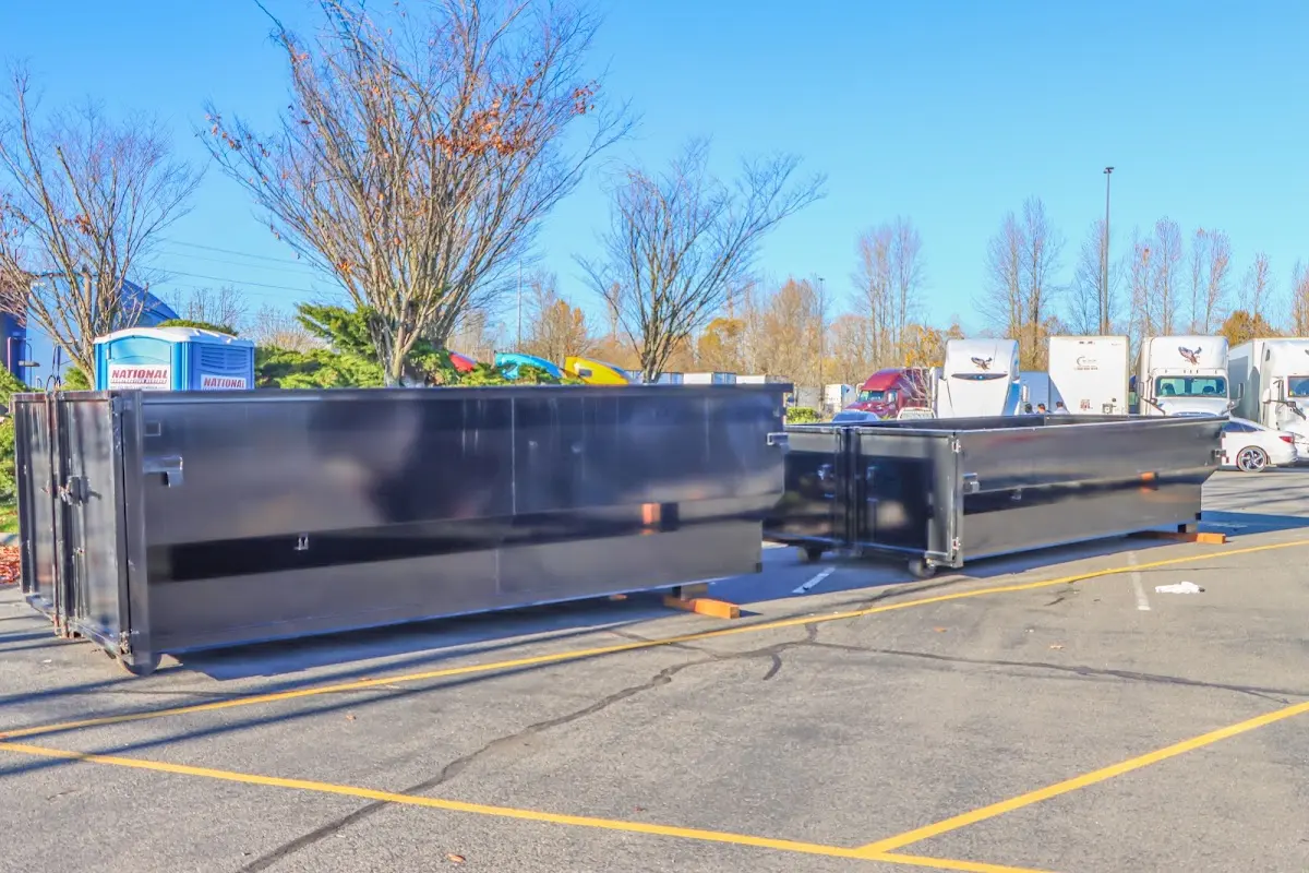 Professional dumpster rental service with roll-off container on residential driveway in Troy